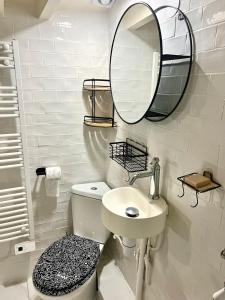 uma casa de banho branca com um lavatório e um espelho em Charmant 2 pièces au cœur du Marais em Paris