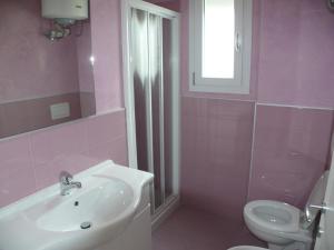Baño rosa con lavabo y aseo en Ferienwohnung für 6 Personen ca 45 qm in Bibione, Adriaküste Italien Bibione und Umgebung - b63277, en Bibione