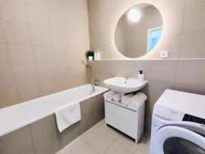 a bathroom with a tub sink and a washing machine at Cinnamon - free private parking - old town - air conditioning in Bratislava +21 photos