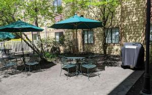 un patio con tavoli e ombrelloni di fronte a un edificio di Extended Stay America Suites - Lancaster County a Mountville