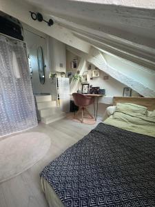 um quarto com uma cama, uma secretária e escadas em Charmant 2 pièces au cœur du Marais em Paris