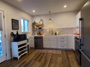a large kitchen with white cabinets and a sink at UPtown. UPscale. UPgraded. 3bd/2ba +Garage & Yard! in Albuquerque