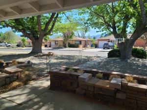 a brick retaining wall with trees and a street at UPtown. UPscale. UPgraded. 3bd/2ba +Garage & Yard! in Albuquerque