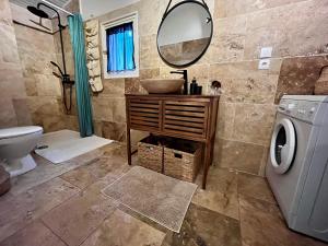 y baño con lavabo, espejo y lavadora. en Maison provençale au calme de la campagne avec Jacuzzi, en Aix-en-Provence