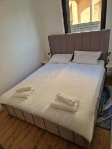a large bed with two towels on top of it at Apartmani Relaxsea in Privlaka +32 photos