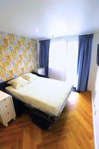 1 dormitorio con 1 cama con cortinas azules y suelo de madera en Superbe studio cocooning Blanzat en Blanzat