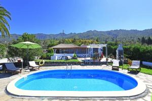 uma piscina com um guarda-sol e uma casa em Ferienhaus mit Privatpool für 5 Personen ca 80 qm in La Punta, La Palma Westküste von La Palma em Tijarafe
