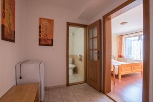 a bathroom with a door open to a bathroom with a tub at Penzion Kormoran in Námestovo