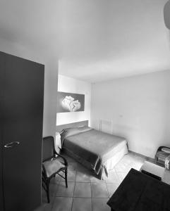 1 dormitorio con 1 cama y 1 silla en GuesthouseAntonia, en Avellino