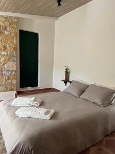 a bedroom with a large bed with towels on it at Quinta dos Avós in Juncal