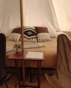 a bed with pillows and a table in a room at Olympic Glamping in Port Angeles