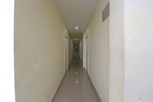 einen leeren Flur in einem Gebäude mit weißen Wänden in der Unterkunft OYO APHA Hotel in Gunadala