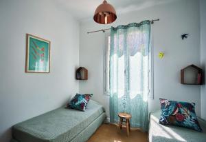a room with two beds and a window with a chair at T3 avec jardin dans Villa Rocaille in Cassis