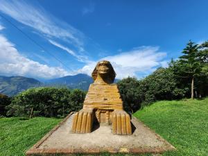 une statue de sphinx assise dans un champ dans l'établissement Hotel Pueblo del Mundo, à Baños
