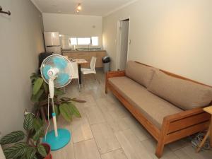 a living room with a couch and a table with a fan at De Triana Hotel in Rancagua