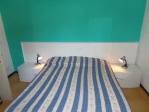 ein Schlafzimmer mit einem Bett und zwei Nachttischen mit Lampen in der Unterkunft Ferienhaus für 6 Personen ca 46 qm in Bibione, Adriaküste Italien Bibione und Umgebung in Bibione