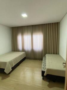 a bedroom with two beds and a window at Sítio Gilmar2filhas in Sete Lagoas