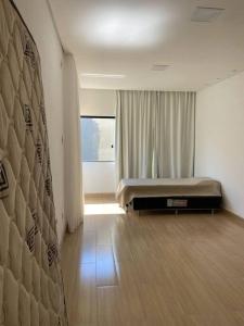 a bedroom with a bed in a room with a window at Sítio Gilmar2filhas in Sete Lagoas