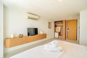 ナタールにあるVip Praia Hotelのベッド1台、テレビ、タオルが備わる客室です。