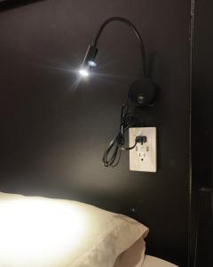 a light attached to a wall above a bed at Art House Hostel Guadalajara in Guadalajara