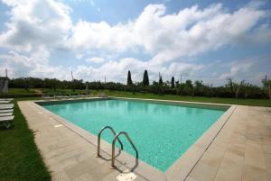 a swimming pool with blue water in a park at Ferienwohnung für 4 Personen ca 60 qm in Cortine, Toskana Chianti in Fattoria Montecchio