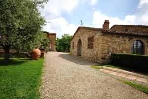 ein altes Steingebäude mit einem Weg neben einem Gebäude in der Unterkunft Studio für 4 Personen ca 60 qm in Cortine, Toskana Chianti in Fattoria Montecchio