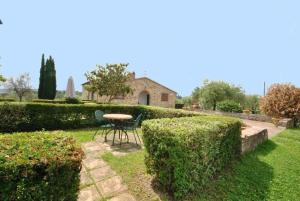 einen Tisch und Stühle im Garten eines Hauses in der Unterkunft Studio für 4 Personen ca 60 qm in Cortine, Toskana Chianti in Fattoria Montecchio