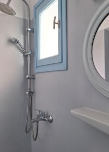 a shower in a bathroom with a mirror and a sink at Giannakis Filoxenia in Filótion