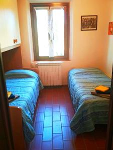 2 Betten in einem Zimmer mit Fenster in der Unterkunft Studio für 6 Personen ca 60 qm in Martignana, Toskana Provinz Florenz in Marcignana