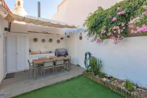een patio met een tafel, stoelen en bloemen bij Ferienhaus für 4 Personen ca 120 qm in Ingenio, Gran Canaria Binnenland Gran Canaria in Ingenio