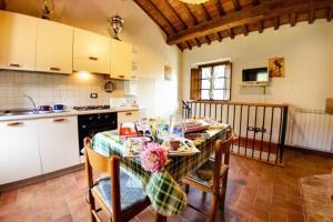 een keuken met een tafel en stoelen en een keuken met witte kasten bij Ferienhaus für 8 Personen ca 100 qm in Buti, Toskana Provinz Lucca in Buti