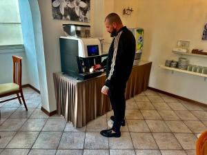 a man in a suit standing at a counter at Hotel Napoleon in Riccione