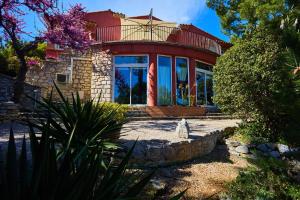 une grande maison rouge avec une grande fenêtre dans l'établissement Appartements avec jardin dans Villa Rocaille, à Cassis