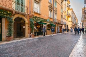 een geplaveide straat in een stad waar mensen lopen bij Residenza Cappello18 in Verona