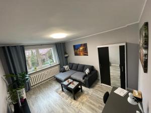 een woonkamer met een bank en een tafel bij Apartament Reszel in Reszel