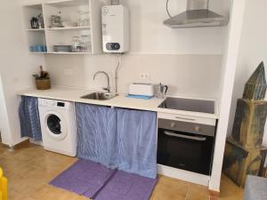 een keuken met een wastafel en een wasmachine bij Vivienda rural en Cabo de Gata in El Pozo de los Frailes