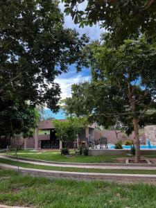 un parc avec des arbres et une piscine en arrière-plan dans l'établissement Villaggio das Árvores, à Retiro