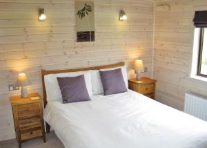 A bed or beds in a room at Wighill Manor Lodges 