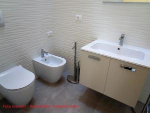een witte badkamer met een toilet en een wastafel bij Ferienwohnung für 7 Personen ca 55 qm in Bibione, Adriaküste Italien Bibione und Umgebung - b63056 in Bibione