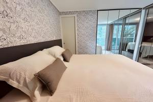1 dormitorio con 1 cama blanca grande con almohadas en Incríveis apartamentos no Solar Tambaú, en João Pessoa