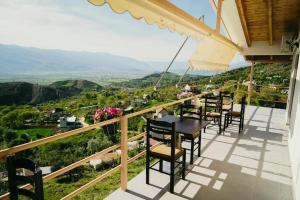 balcón con mesas y sillas y vistas al valle en Bujtina ANLU en Gjirokastër