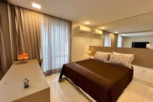 1 dormitorio con cama y ventana grande en Incríveis apartamentos no Solar Tambaú, en João Pessoa