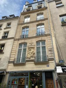 um edifício alto com janelas do lado em Charmant 2 pièces au cœur du Marais em Paris