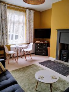 a living room with a couch and a table at The Cobbles - Central, Parking, Netflix & Woodburner in Hebden Bridge