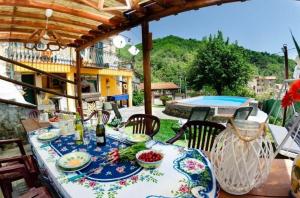 een tafel met borden eten op een patio met een zwembad bij Ferienhaus mit Privatpool für 4 Personen ca 90 qm in Lanciole, Toskana Provinz Pistoia in Lanciole