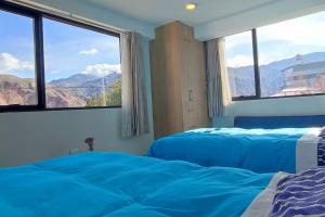 een slaapkamer met een bed en uitzicht op de bergen bij Casa de las Flores, Valle Sagrado Cusco in Urubamba