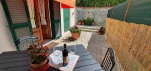 uma mesa com uma garrafa de vinho no pátio em Ferienhaus mit Privatpool für 2 Personen ca 40 qm in Capannori, Toskana Provinz Lucca em Capannori