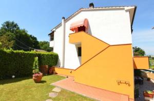 uma pequena casa com uma grande casa amarela em Ferienhaus mit Privatpool für 2 Personen ca 40 qm in Capannori, Toskana Provinz Lucca em Capannori