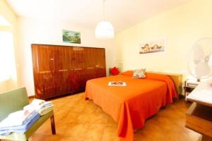 um quarto com uma cama com um cobertor laranja em Ferienhaus mit Privatpool für 2 Personen ca 40 qm in Capannori, Toskana Provinz Lucca em Capannori