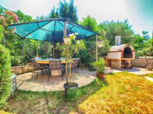 een patio met een tafel en een parasol in een tuin bij Ferienwohnung für 4 Personen ca 35 qm in Pula-Fondole, Istrien Istrische Riviera - b63319 in Štinjan